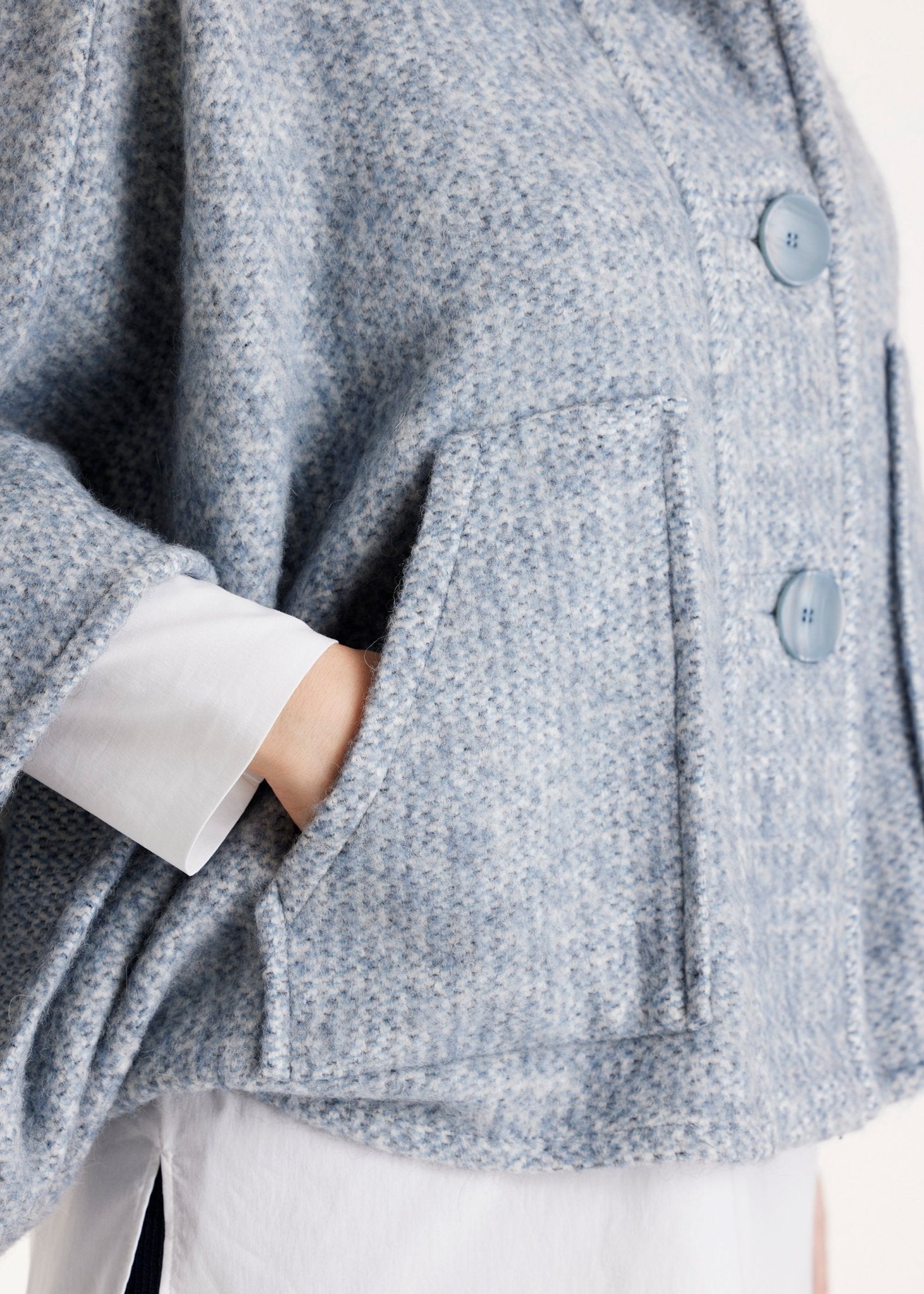 Weites Cape YAMYKA mit Kragen, Knopfleiste und großen Taschen aus grobem Stoff in Hellblau