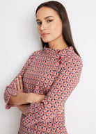 Schmales Kleid ELNYRA in Knielänge mit Rundhalsauschnitt, Knöpfen an der Schulter, Ärmeln in 3/4-Länge und orangefarbenem Muster